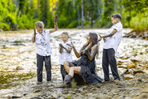 A mom and her 3 boys playing in the river during a family photo session in Garden Valley, Idaho.