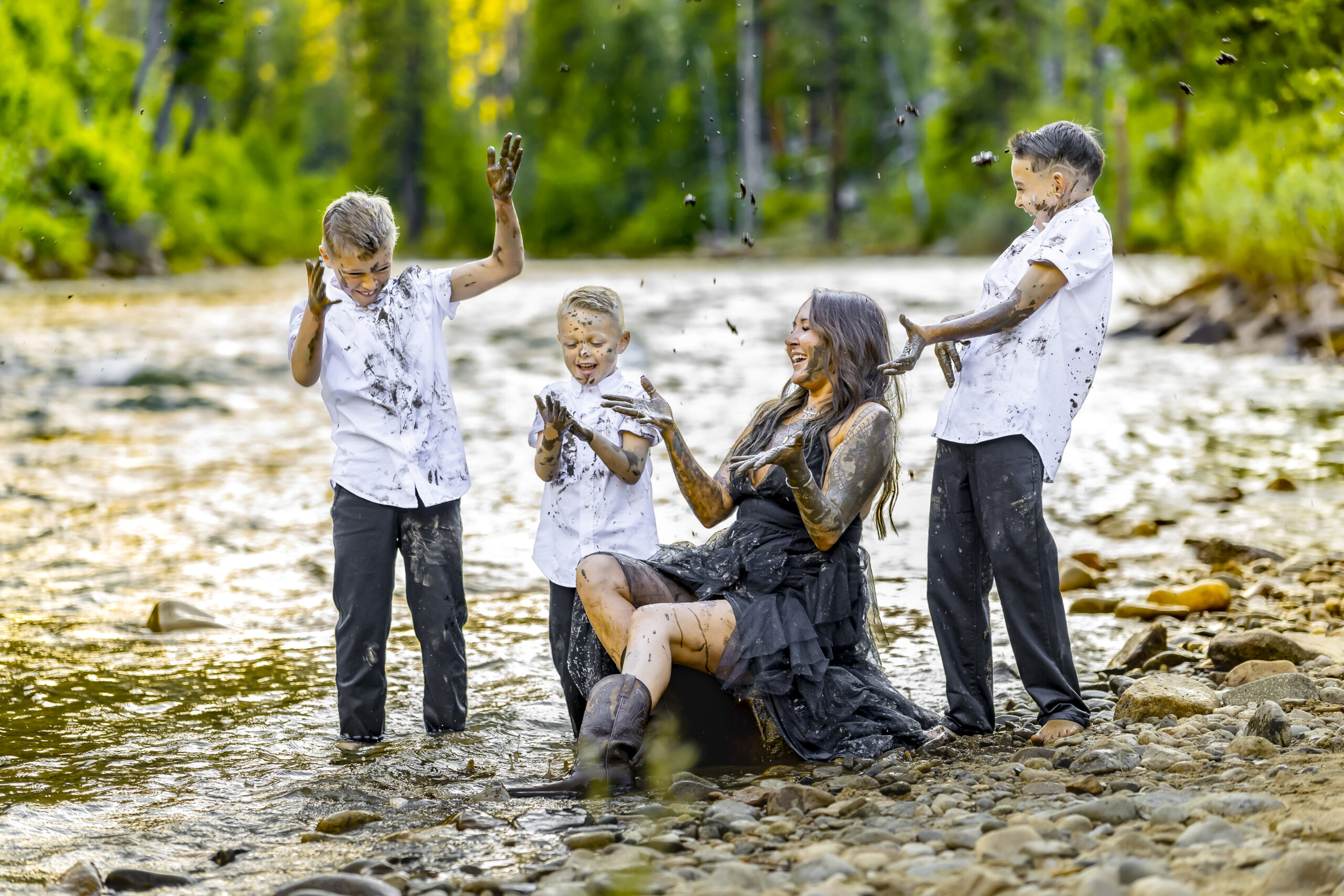A mom and her 3 boys playing in the river during a family photo session in Garden Valley, Idaho.